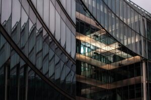 Façade en verre de bâtiment moderne au crépuscule.