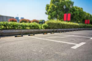 Parking vide en journée avec végétation.